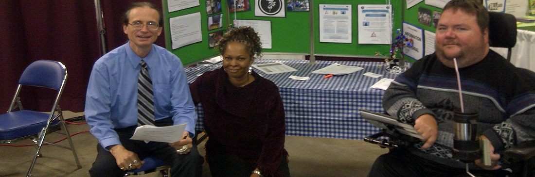 K-W Accessability staff sitting in front of a display about the organization.