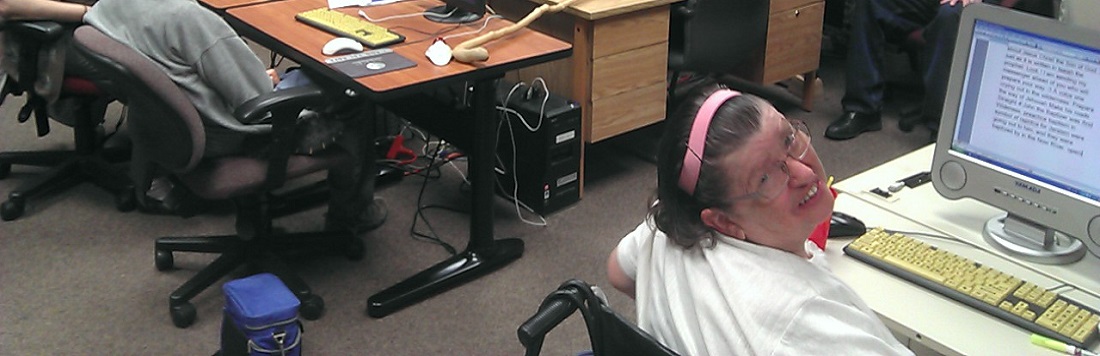 A woman working on a Word document on a community computer.