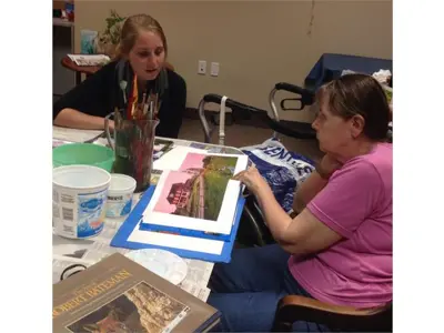 Volunteer helping the member to pick the picture to draw